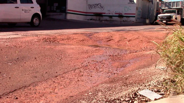 Solicitan reparación por bache y fuga de agua